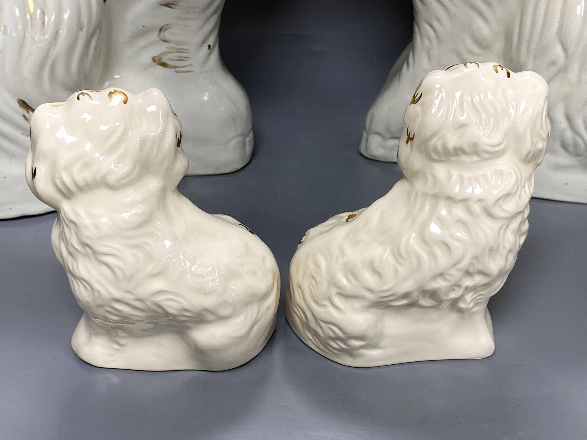 A large pair of Victorian Staffordshire pottery comforter spaniels, 39cm and a pair of Royal Doulton comforter spaniels, 14cm